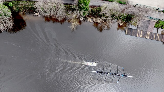 An eight along the bank, the coach launch ahead